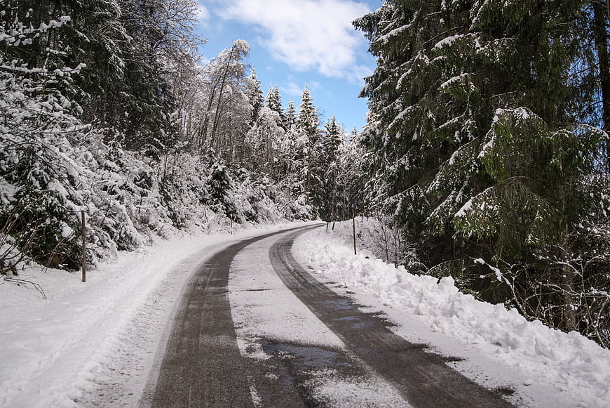 Winding Snow-Covered Road Through Winter Forest