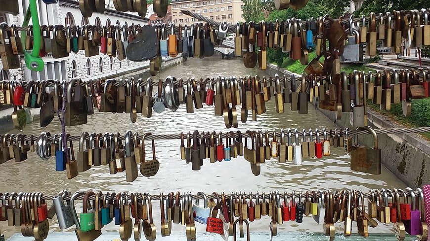 Love locks hanging on bridge cables over river in Ljubljana