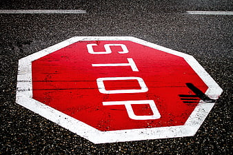 Red Stop Sign Painted on Asphalt Road Surface