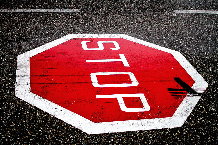 Red Stop Sign Painted on Asphalt Road Surface