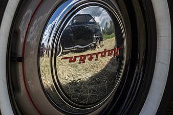 Close-up of vintage car hubcap with reflection
