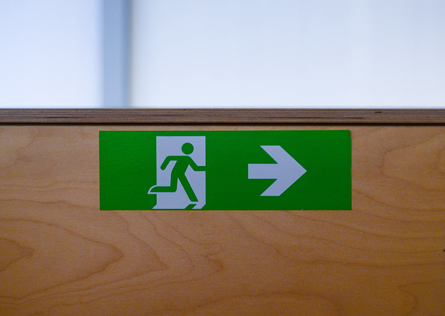 Green emergency exit sign on wooden wall