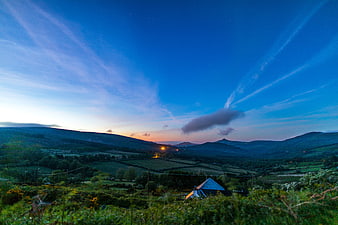 Blue Hour Landscape with Rolling Hills and Distant Lights