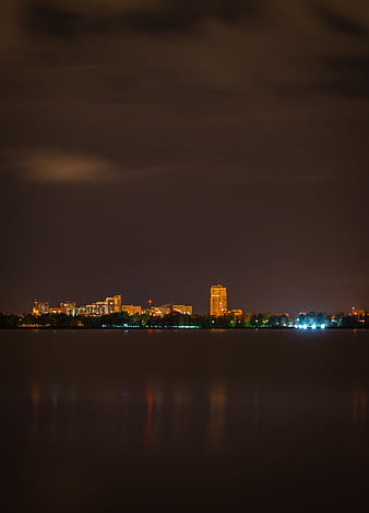 Night cityscape skyline with lights reflecting on calm water