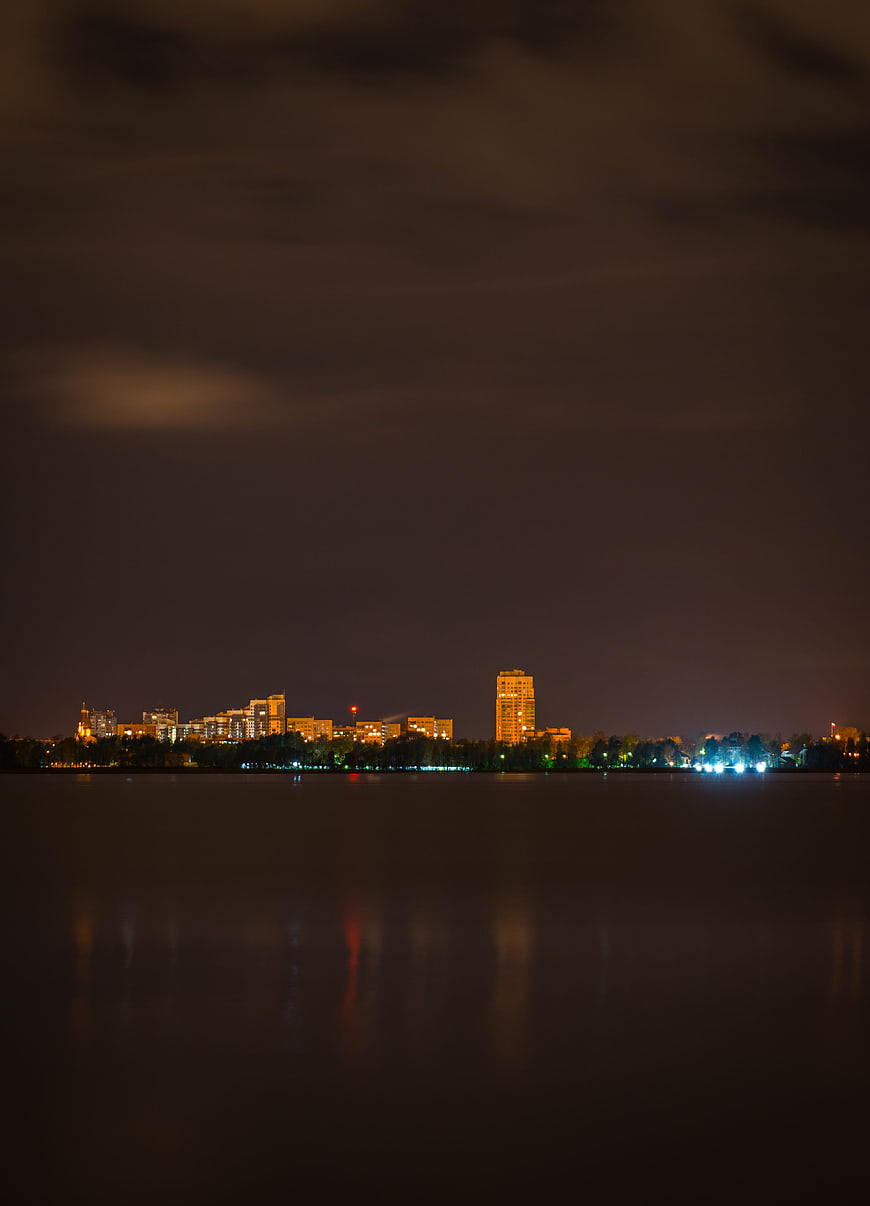 Night cityscape skyline with lights reflecting on calm water