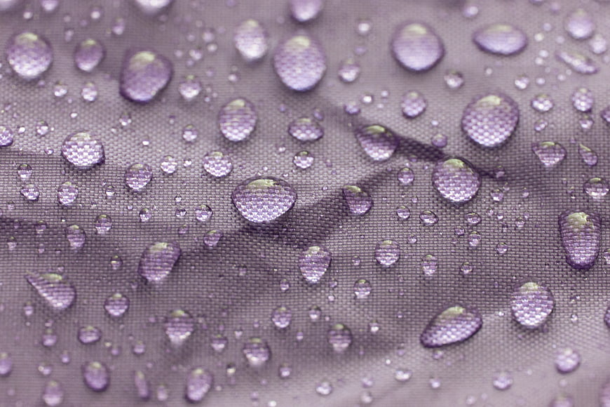 Macro Water Droplets on Purple Textured Fabric