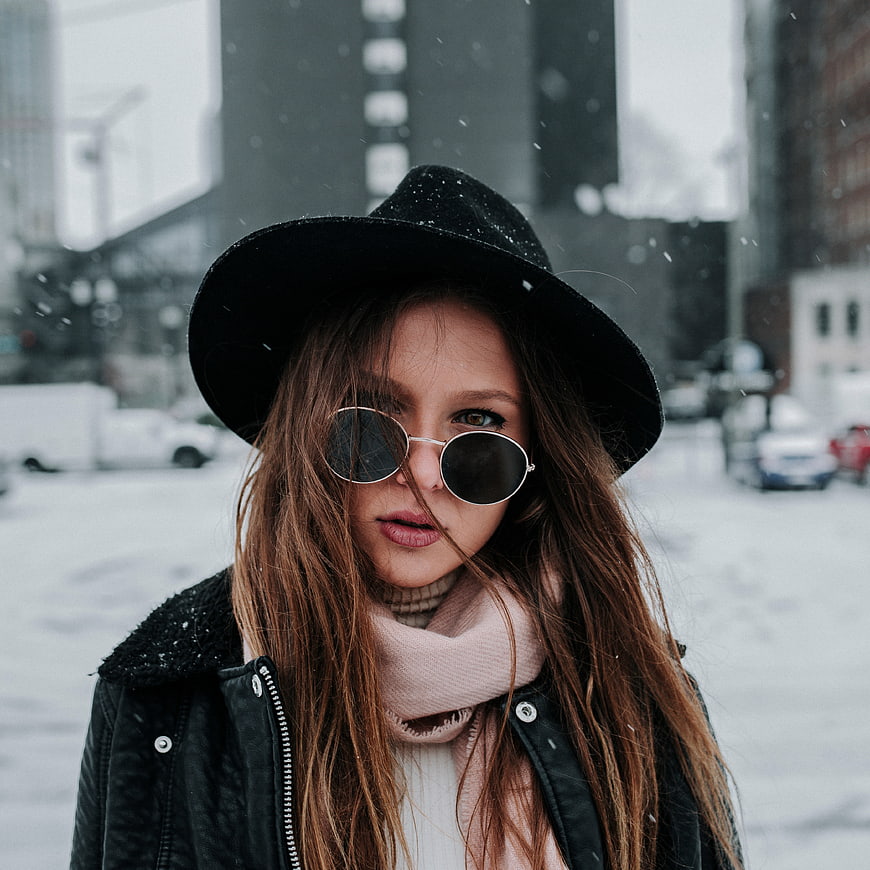 Stylish Woman in Winter Fashion with Hat and Sunglasses in Snow