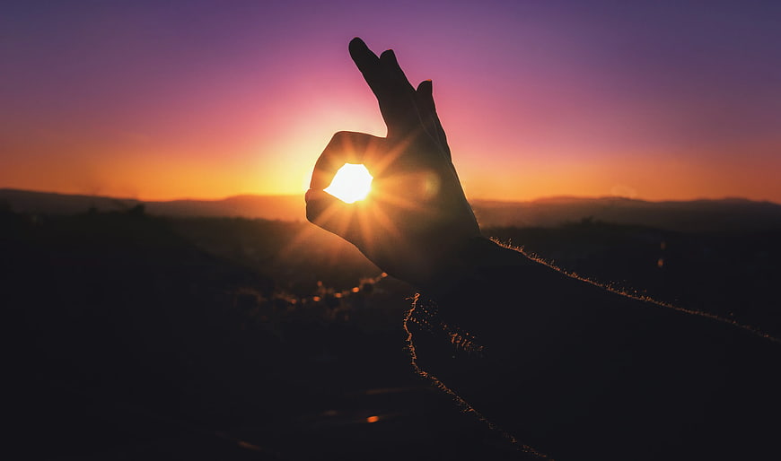 Hand Holding Sun Silhouette at Sunset
