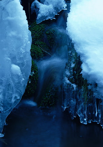 Frozen Stream with Ice Formations and Snow in Winter