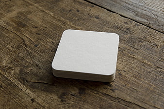 Blank White Paper Coaster Stack Mockup on Rustic Wooden Table