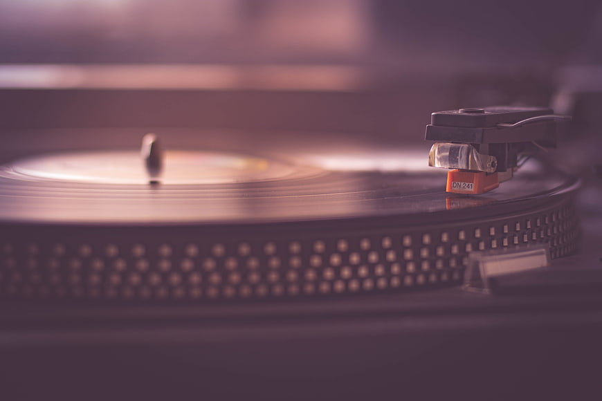 Close-up of a vinyl record player with a stylus on a spinning disc