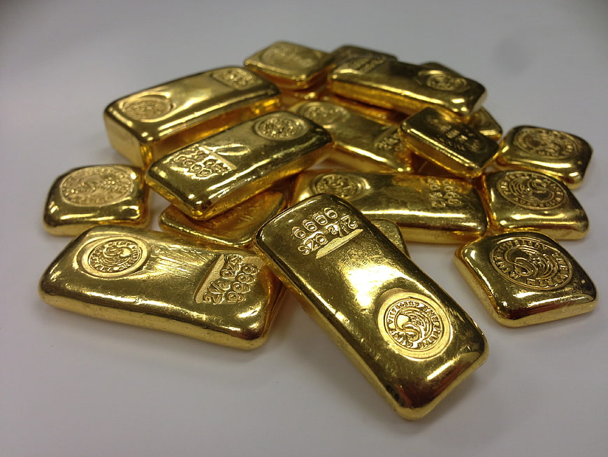Pile of shiny gold bars on white background