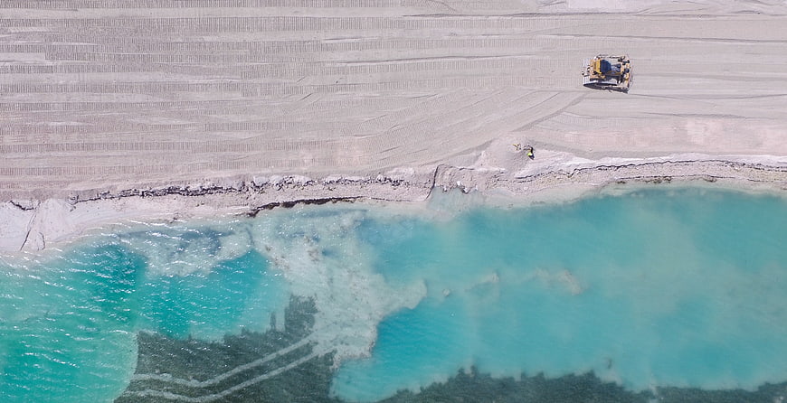 Aerial view of turquoise water and sand mining operation