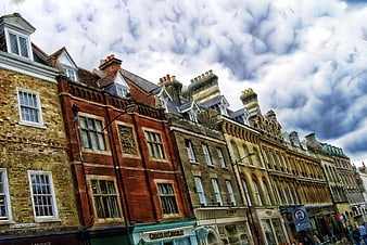 Colorful historic row houses under dramatic cloudy sky