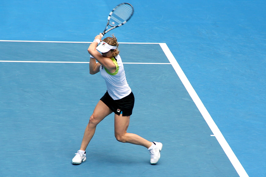 Female Tennis Player Serving on Blue Court