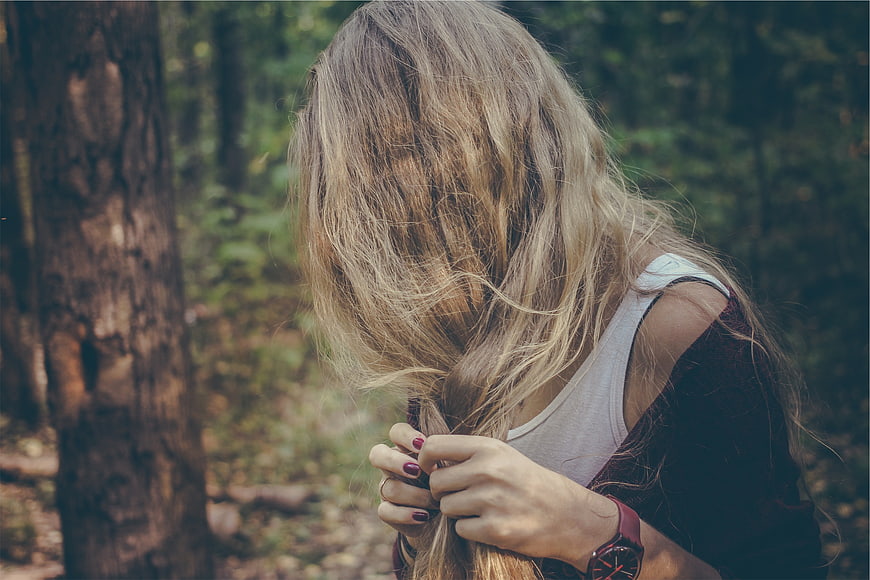 Woman with long blonde hair in forest