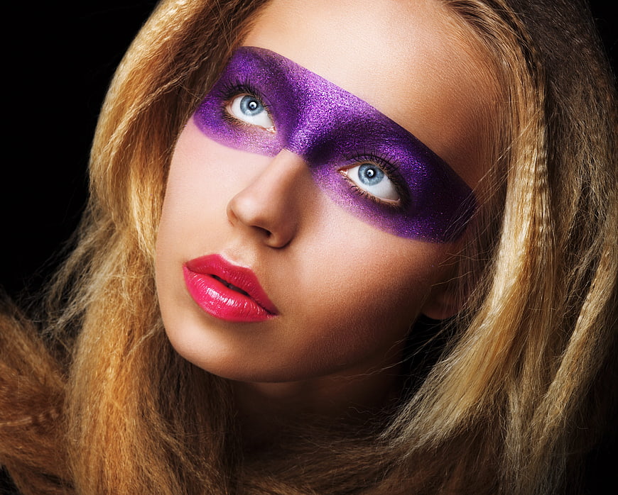 Woman with purple glitter mask makeup and pink lips