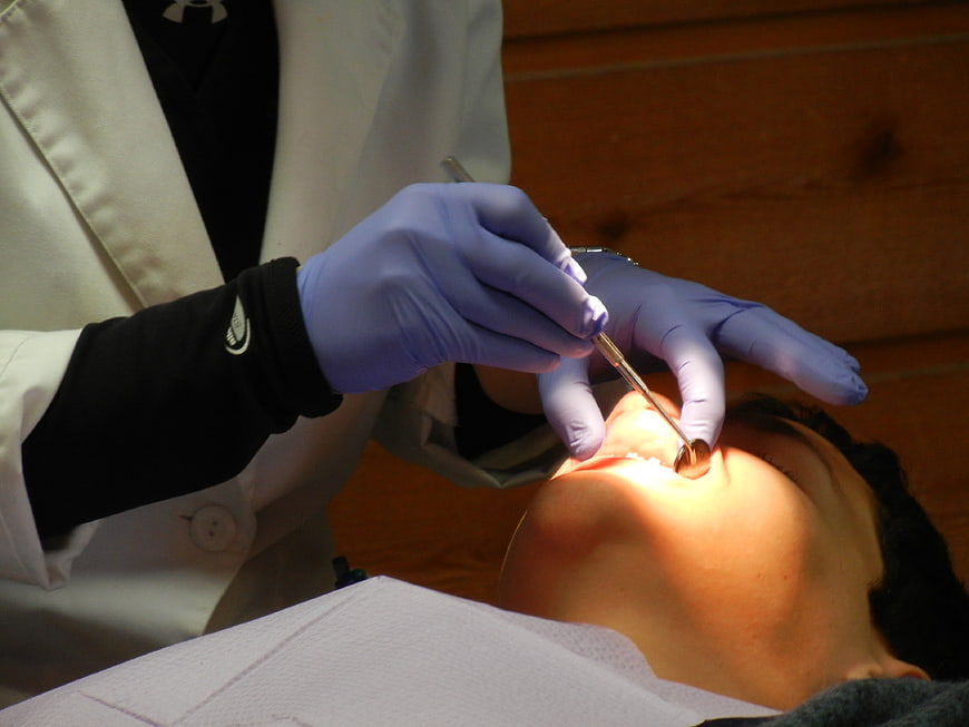 Dentist examining patient teeth with mirror and probe