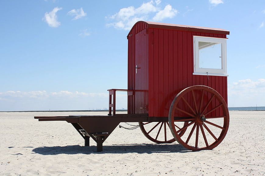 Red Vintage Beach Cart on Sandy Shore