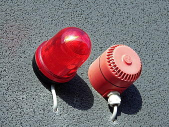 Red emergency warning light and siren on textured wall