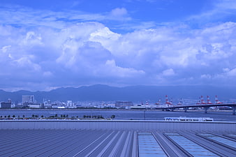 Blue sky with clouds over industrial port and cityscape