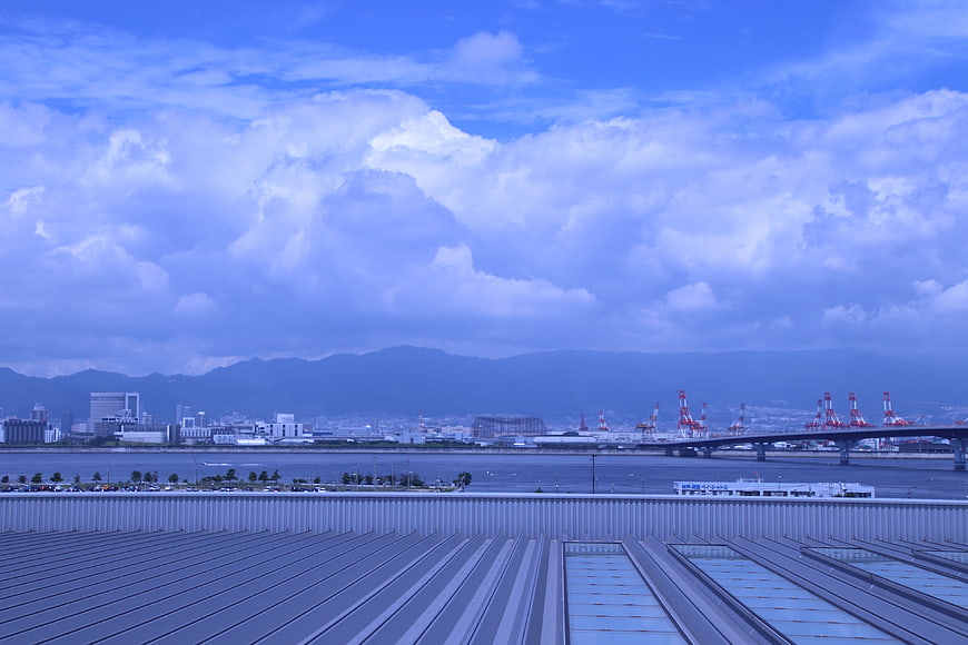 Blue sky with clouds over industrial port and cityscape