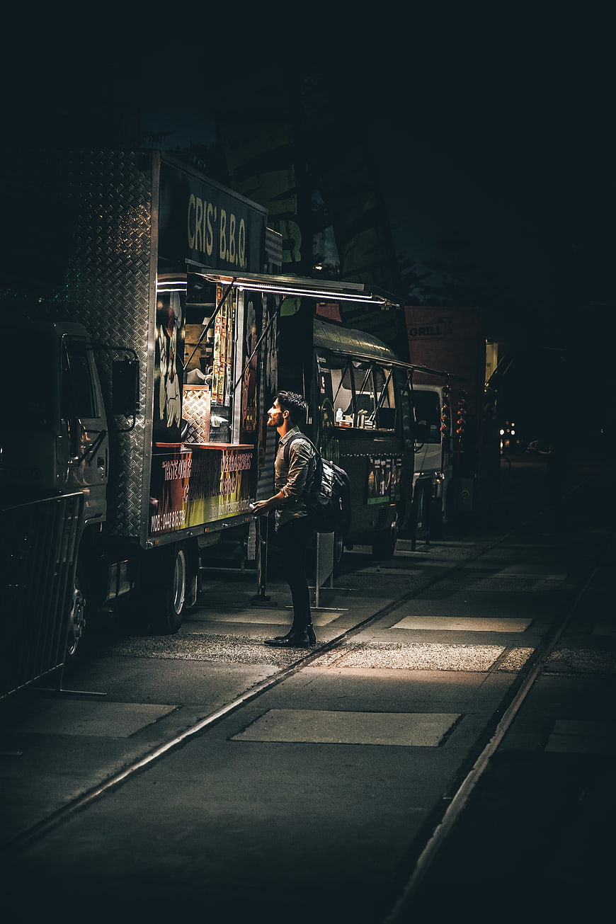 Man standing at food truck at night