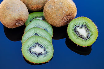 Fresh Kiwi Fruit Slices And Whole Fruits On Blue Background