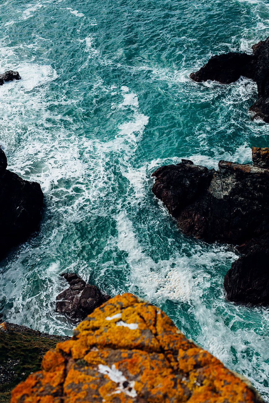 Aerial View of Turquoise Waves Crashing Against Rocky Coastline