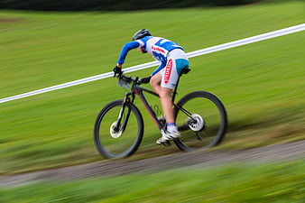 Cyclist racing on mountain bike with motion blur