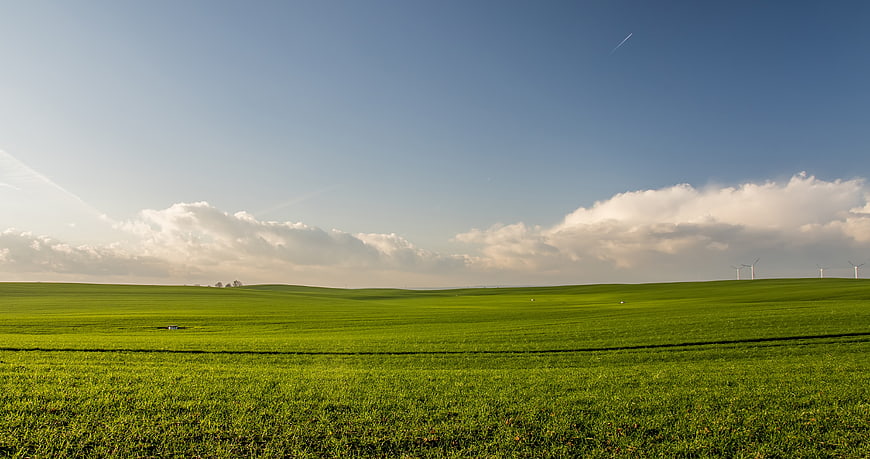 Vibrant Green Rolling Hills with Wind Turbines and Blue Sky
