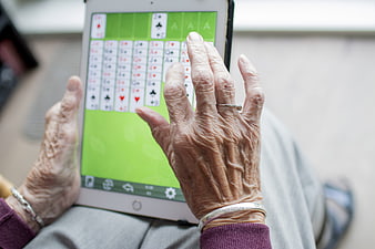 Senior woman playing solitaire on a tablet computer