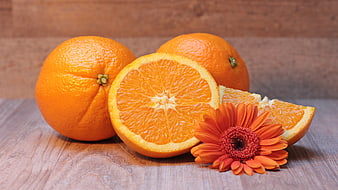Fresh Oranges and Gerbera Daisy on Wooden Table