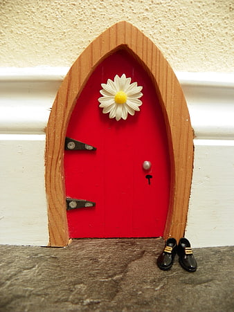 Miniature red fairy door with daisy and tiny shoes