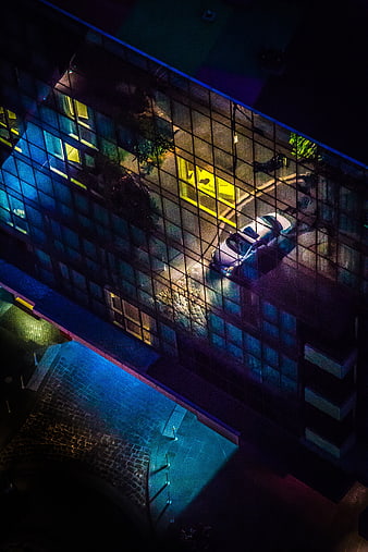 Aerial Night View of Modern Glass Building with Car Reflection