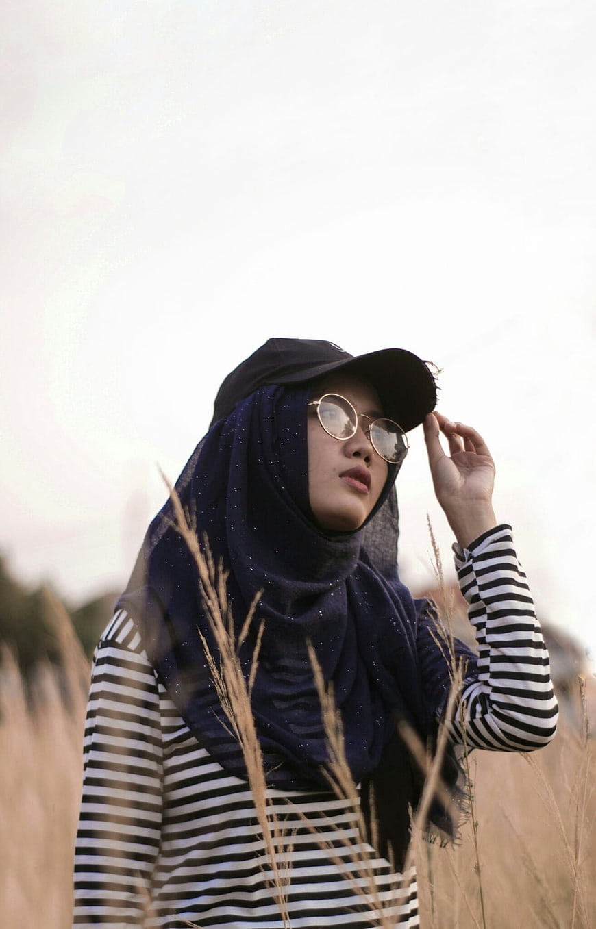 Woman in Hijab and Striped Shirt in Field