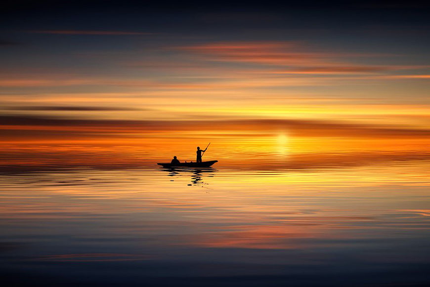 Silhouette of Two People Fishing in a Boat at Sunset