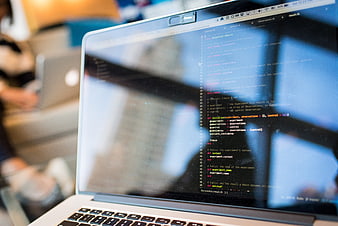Close-up of Ruby code on laptop screen with office background
