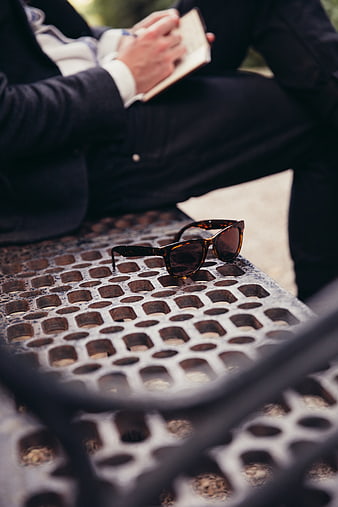 Tortoiseshell Sunglasses on Metal Bench with Man Reading