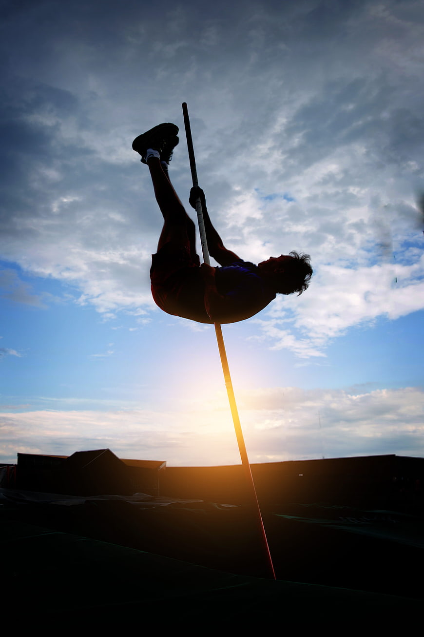 Silhouette of Male Pole Vaulter Against Sunset Sky