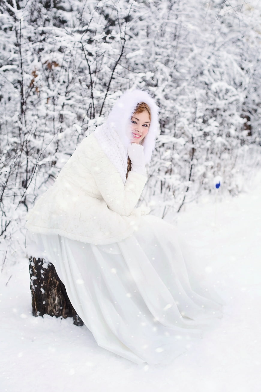 Woman in White Fur Hooded Dress in Snowy Forest