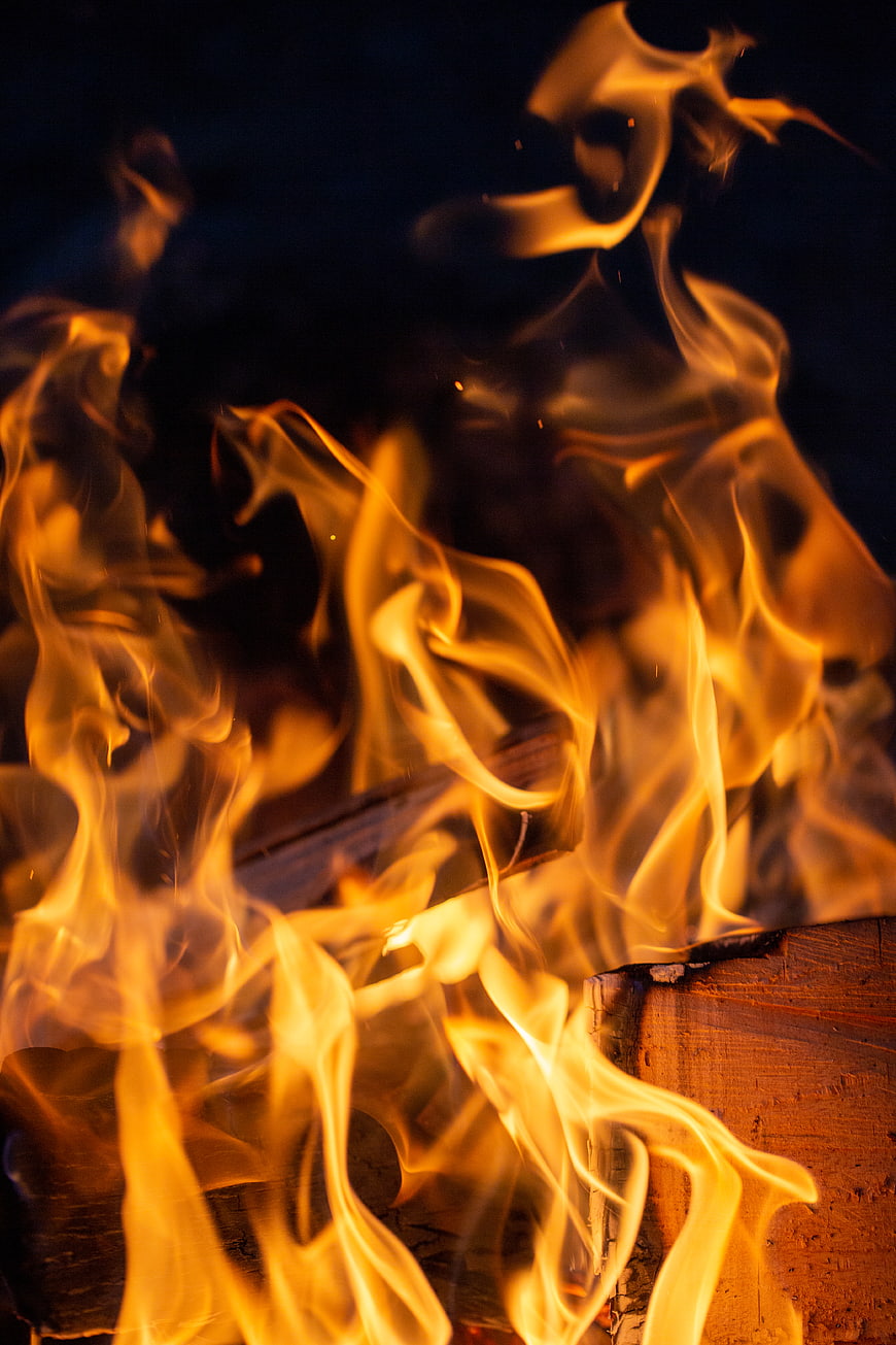 Close-up of vibrant orange flames burning on wood logs