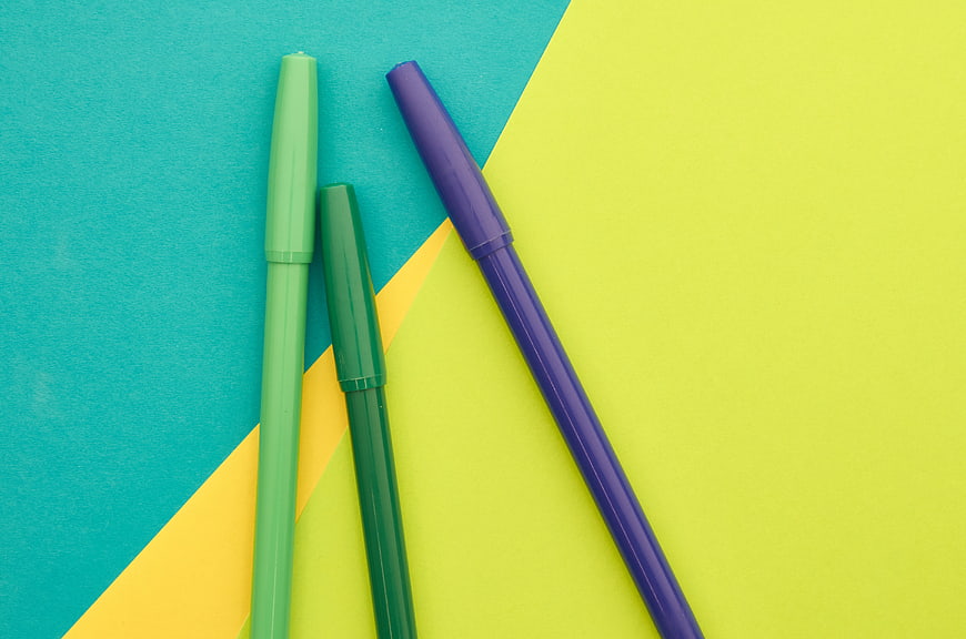 Colorful markers on geometric pastel background