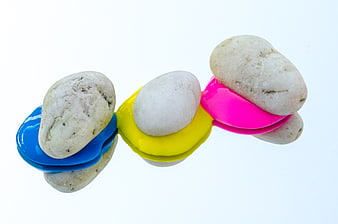 Colorful Pebbles on Paint Drops White Background