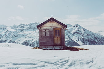 Isolated wooden cabin in snowy mountain landscape