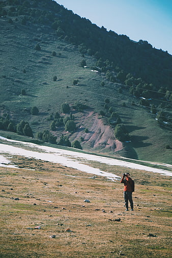 Photographer Taking Pictures in Mountainous Highland Landscape