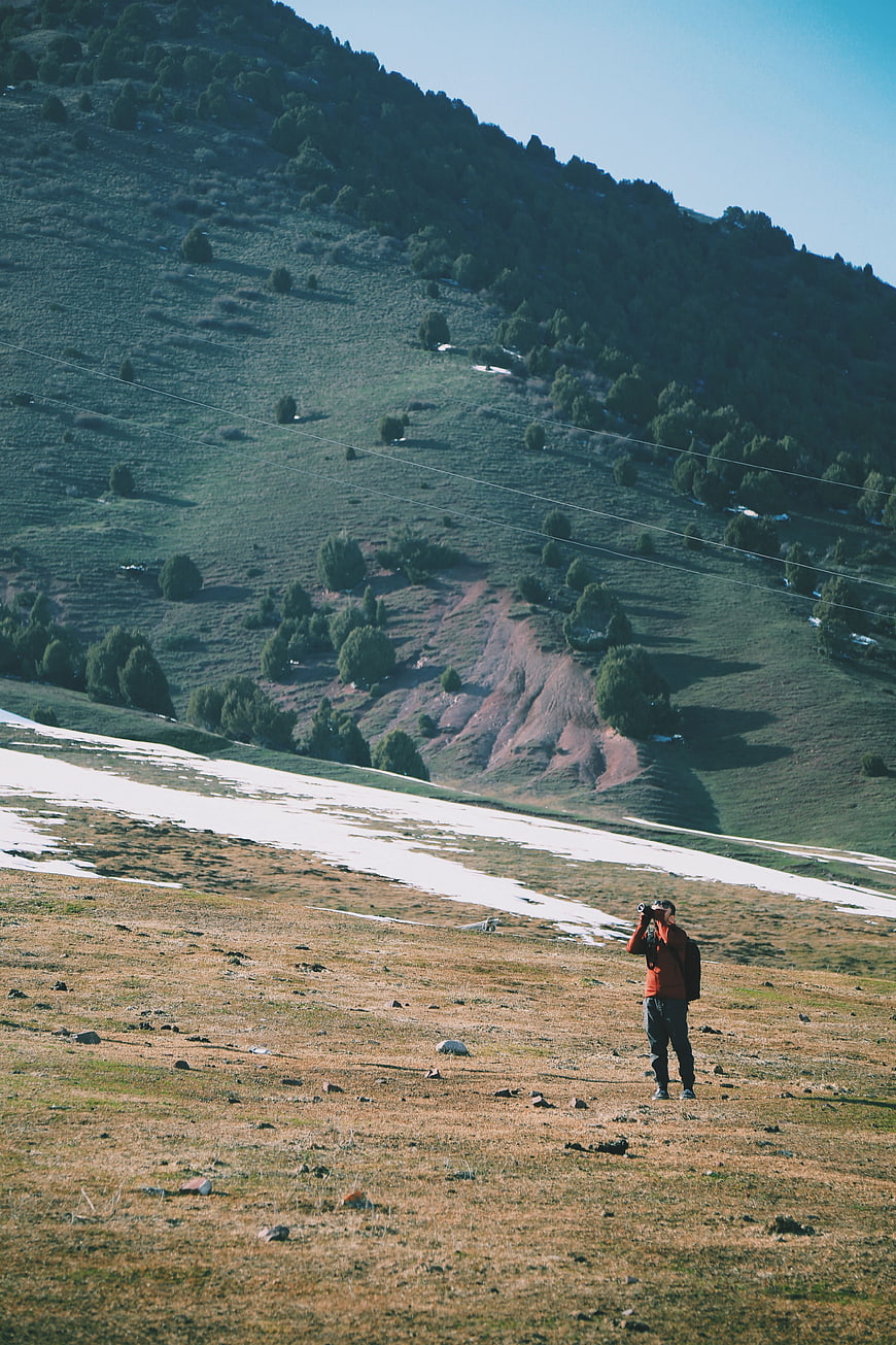 Photographer Taking Pictures in Mountainous Highland Landscape