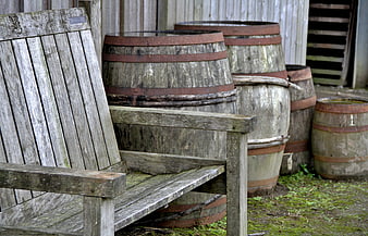 Weathered Wooden Bench And Rustic Barrels Against Barn Wall