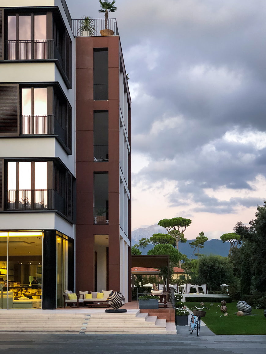 Modern luxury hotel exterior with dramatic sky and mountains