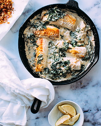 Overhead shot of creamy salmon and spinach in cast iron skillet